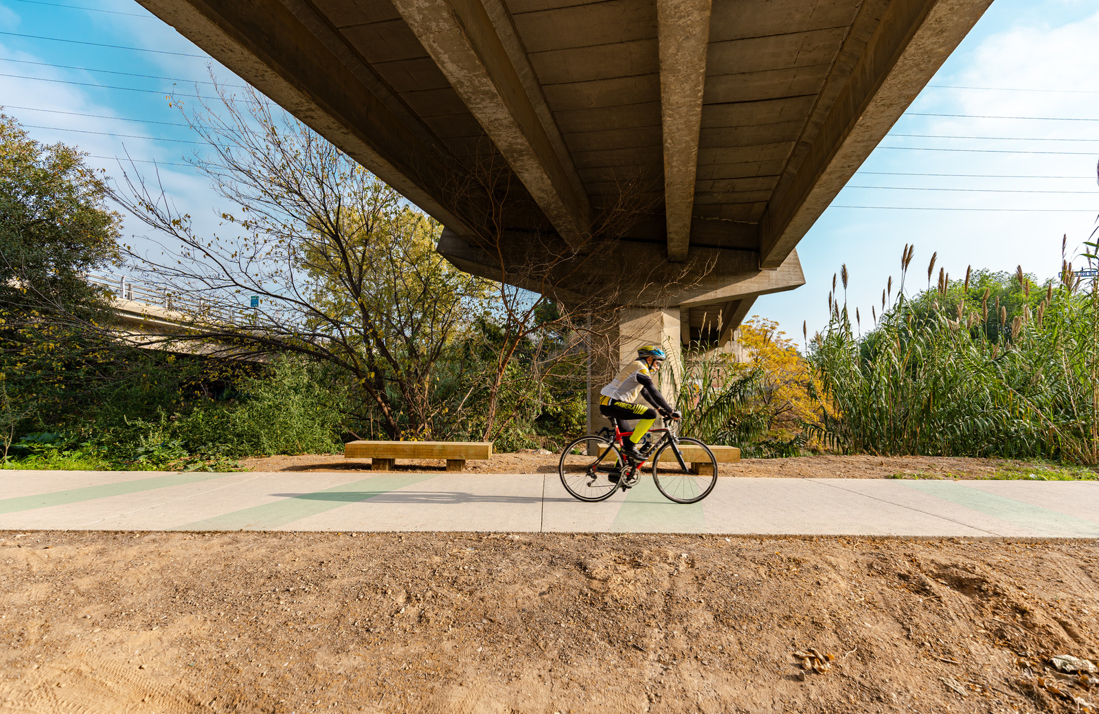 ciclista pel camí sota un pont